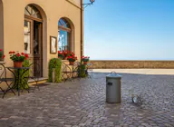 The same café square with the scooter removed and the trash bin left in place